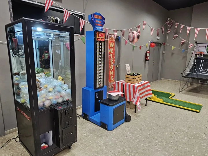 Máquina de gancho de alquiler en una fiesta de feria con otros juegos