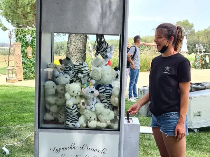 Invitada jugando a la grúa de peluches en una boda