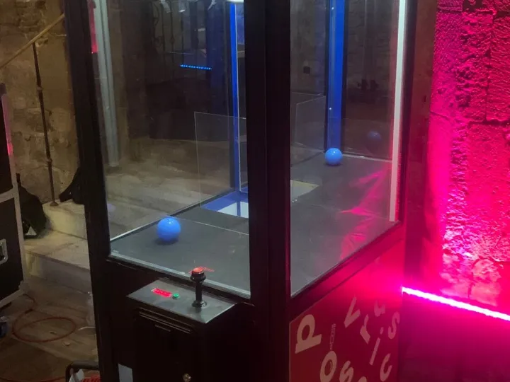 Grúa de peluches negra con vinilo decorativo e iluminación rosa