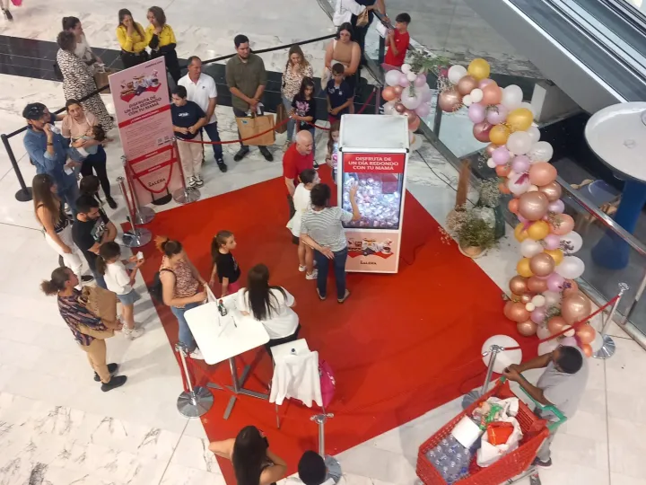 Activación con máquina de gancho y cola de público en un centro comercial