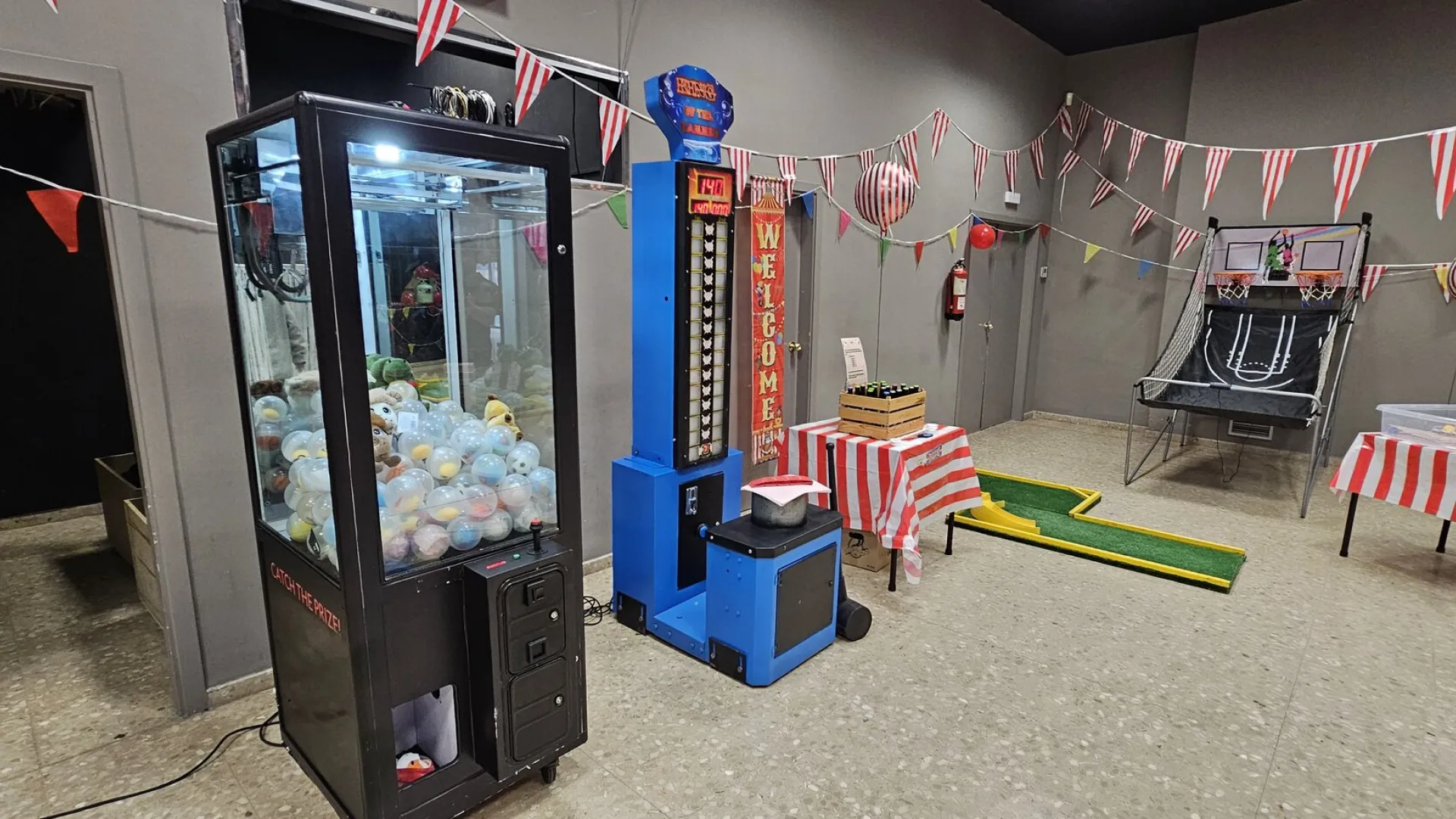 Máquina de gancho de alquiler en una fiesta de feria con otros juegos