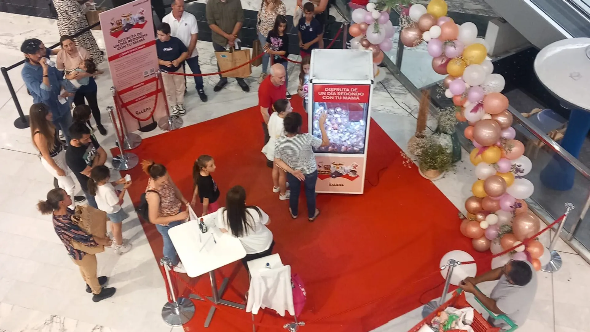 Activación con máquina de gancho y cola de público en un centro comercial