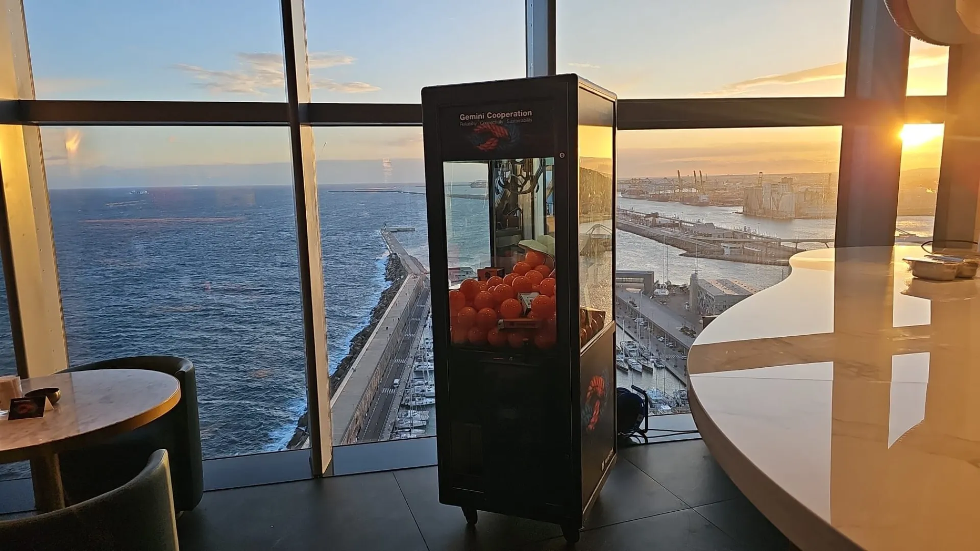 Máquina de gancho con bolas naranjas en un evento con vistas al mar
