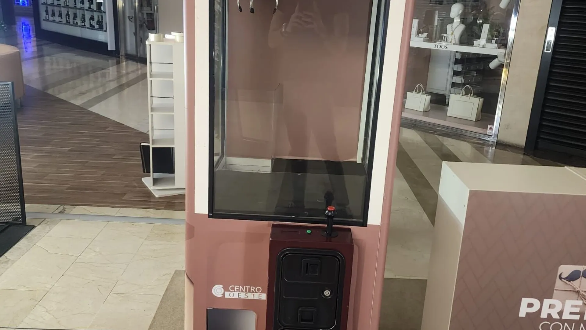 Máquina de gancho vinilada en un centro comercial con el lema Premios con mucho gancho