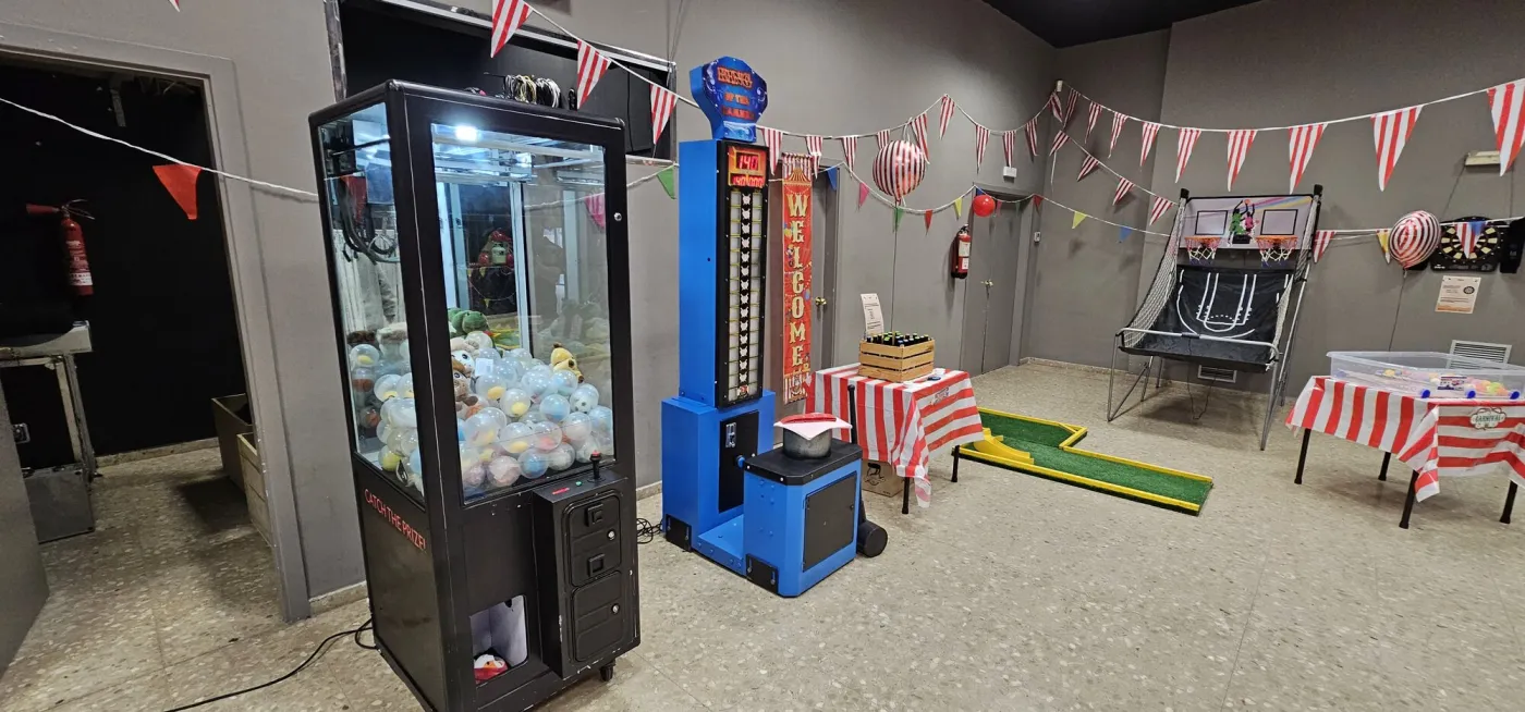 Máquina de gancho de alquiler en una fiesta de feria con otros juegos