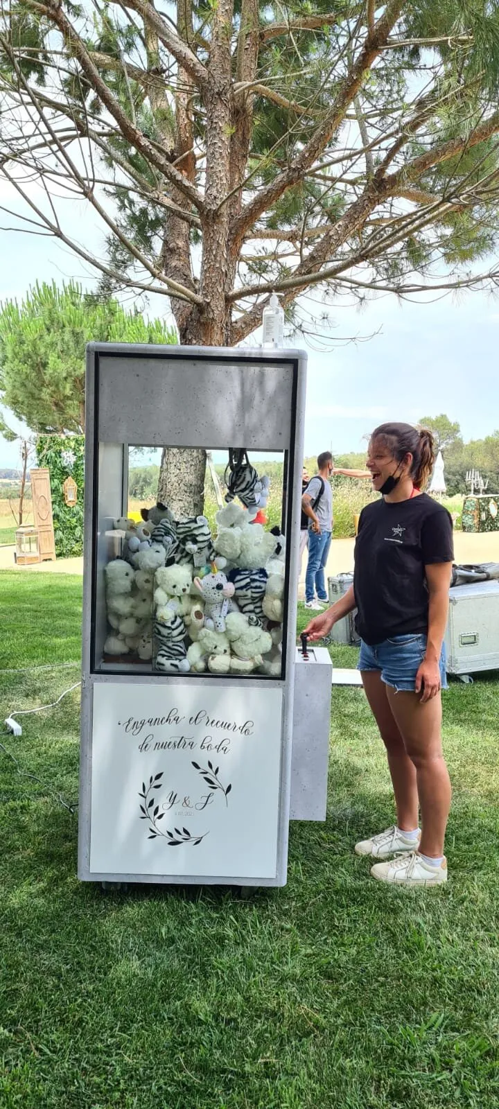 Invitada jugando a la grúa de peluches en una boda