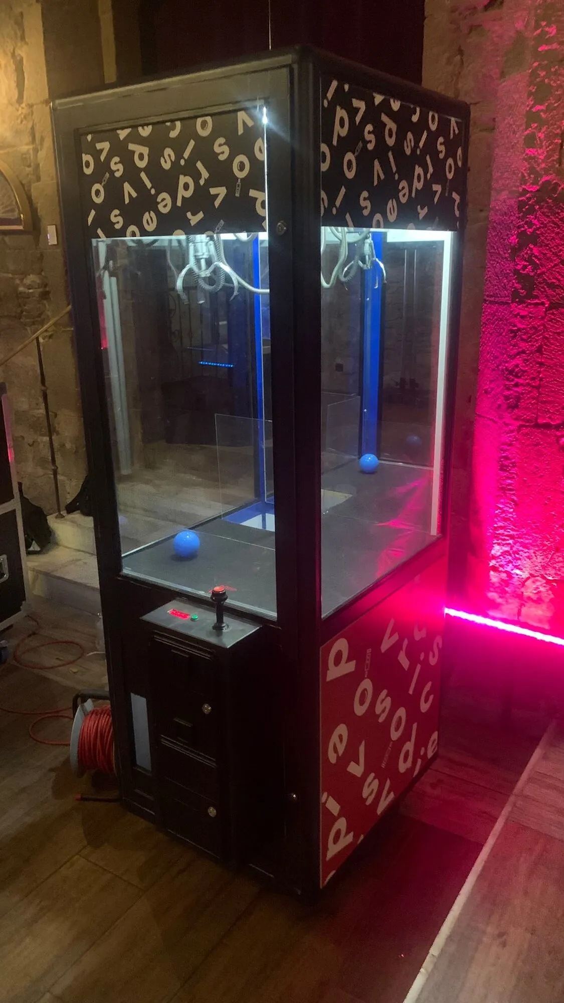 Grúa de peluches negra con vinilo decorativo e iluminación rosa