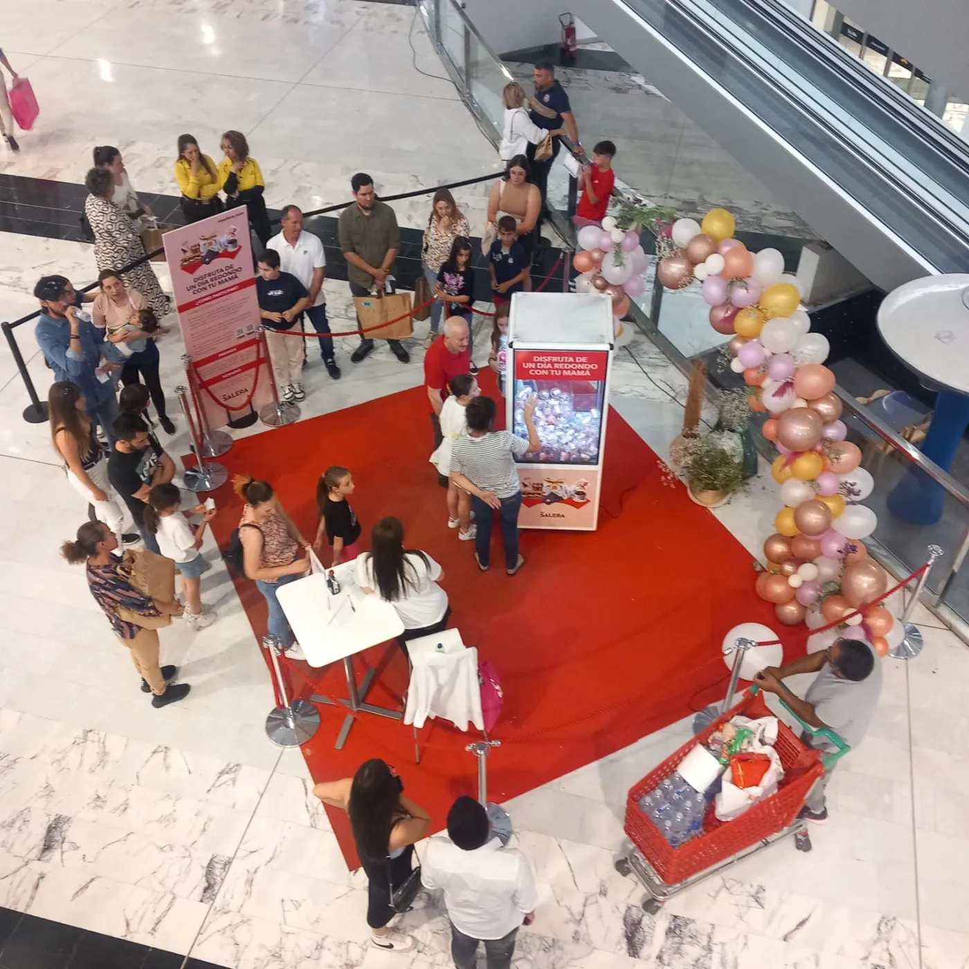 Activación con máquina de gancho y cola de público en un centro comercial